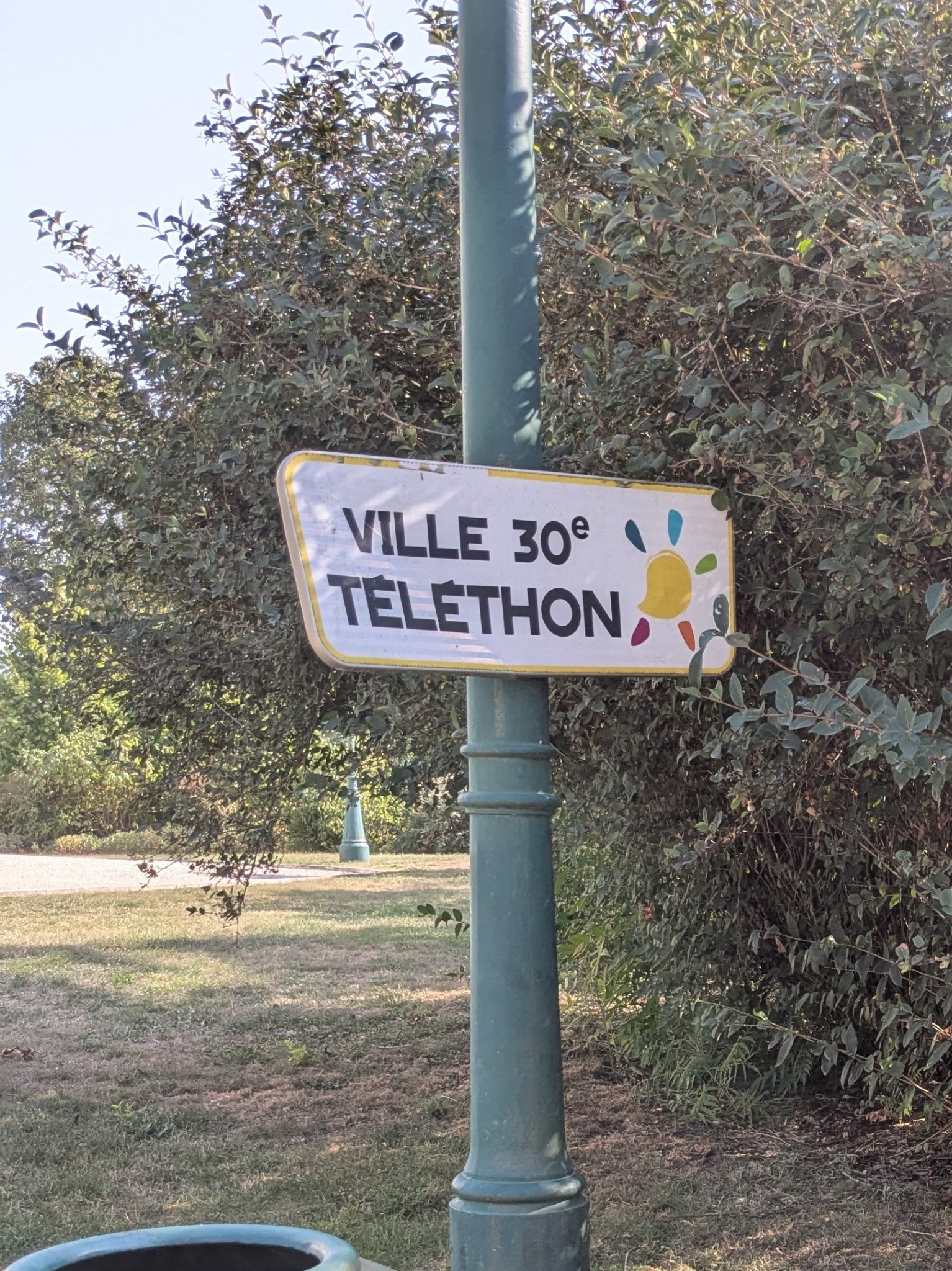Panneau de type signalisation sur un poteau, avec indiqué "VILLE 30e TÉLÉTHON" et le logo de l'AFM-Téléthon Panneau de type signalisation sur un poteau, avec indiqué "VILLE 30e TÉLÉTHON" et le logo de l'AFM-Téléthon