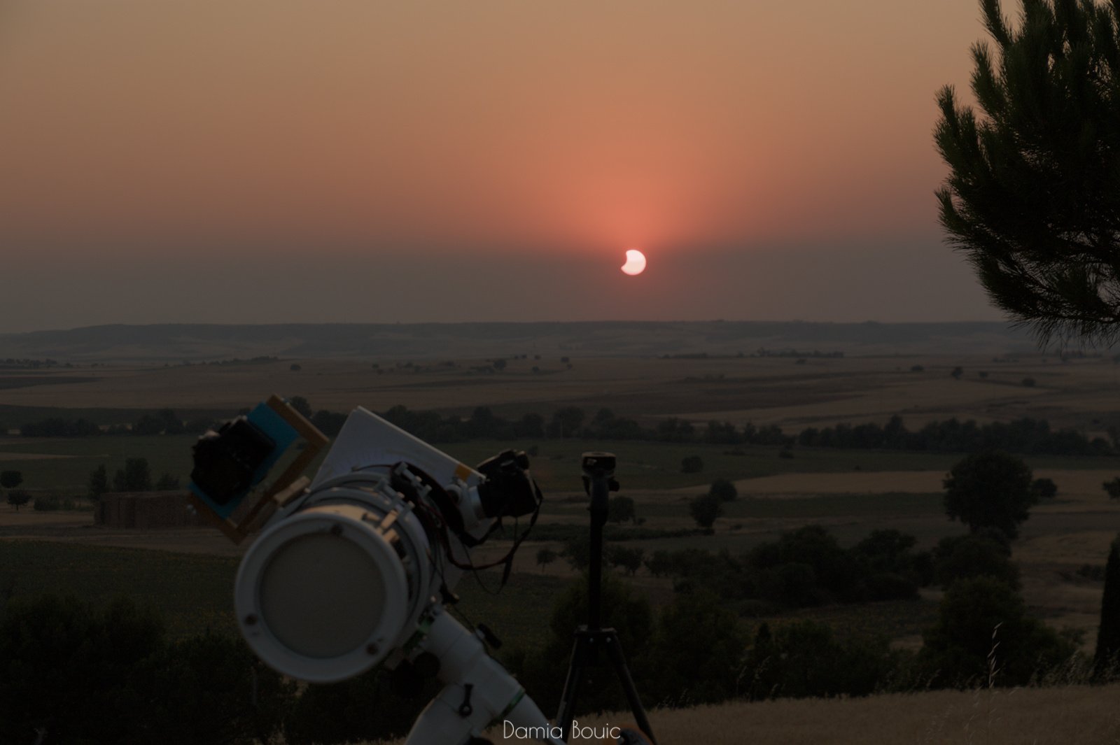 Mon télescope installé sur sa monture, vu de derrière, où l'on voit le miroir de dos. Sur le flanc est posé un appareil photo.
En arrière-plan, le Soleil partiellement éclipsé se couche, fortement absorbé par une couche de poussières près de l'horizon. Mon télescope installé sur sa monture, vu de derrière, où l'on voit le miroir de dos. Sur le flanc est posé un appareil photo.
En arrière-plan, le Soleil partiellement éclipsé se couche, fortement absorbé par une couche de poussières près de l'horizon.