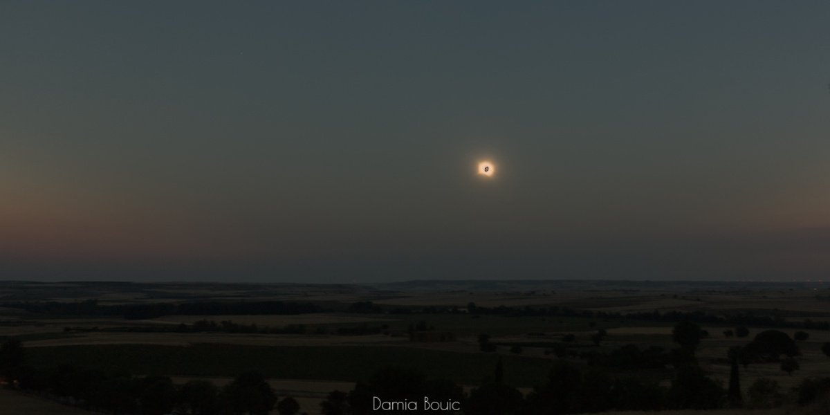 Paysage doucement vallonné du plateau semi-désertique espagnol.
Immédiatement, l'on peut voir l'ombre lunaire posée sur l'atmosphère, le ciel qui est sombre. Et puis, un cercle noir entouré de lumière. Le Soleil éclipsé.
Une lunette astro pointe le spectacle en bas à droite. Paysage doucement vallonné du plateau semi-désertique espagnol.
Immédiatement, l'on peut voir l'ombre lunaire posée sur l'atmosphère, le ciel qui est sombre. Et puis, un cercle noir entouré de lumière. Le Soleil éclipsé.
Une lunette astro pointe le spectacle en bas à droite.