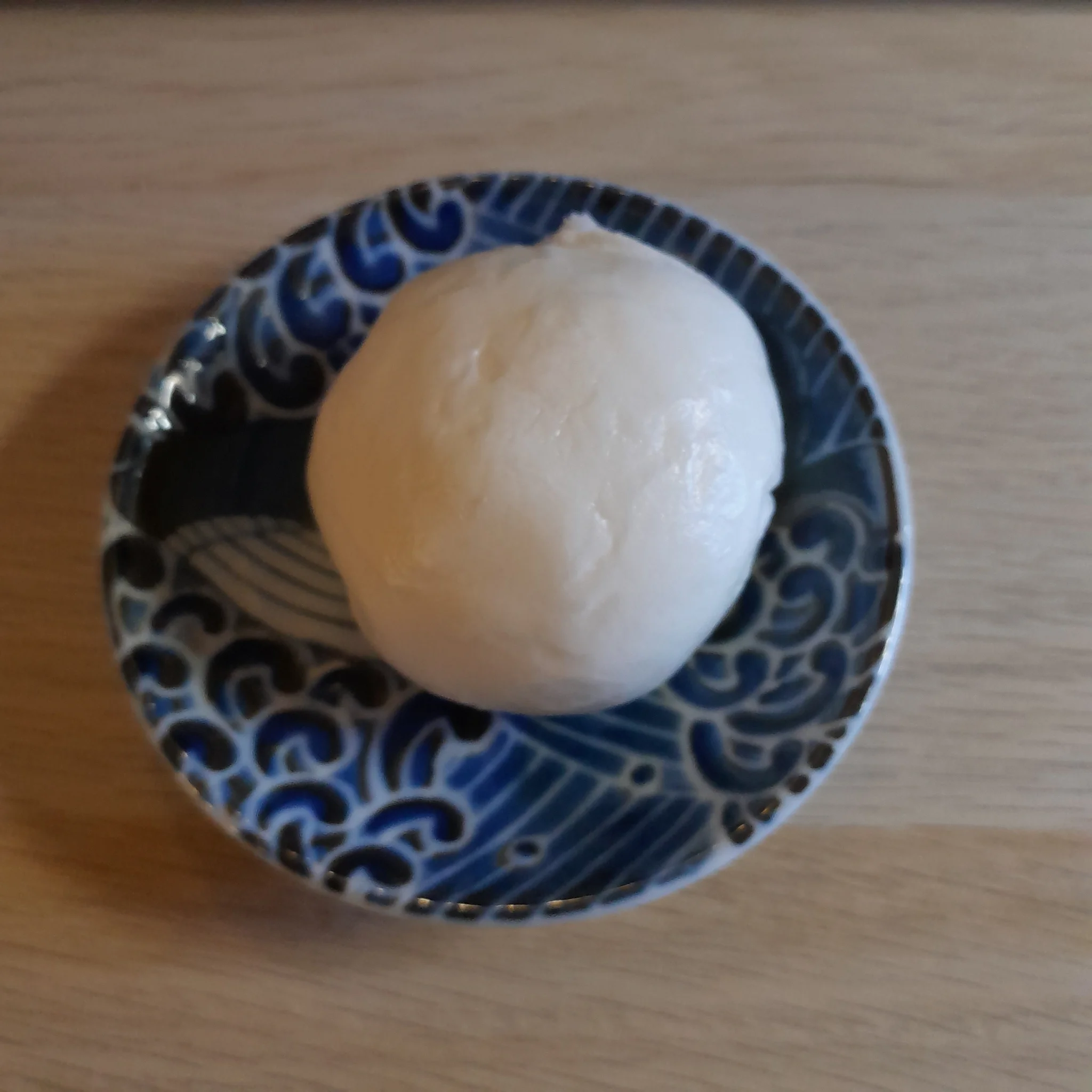 un dessert asiatique: une boule de pâte fourrée à la pâte de lotus cuite à la vapeur. dans une petite assiette bleue avec un motif baleine, pour plus de choupi. un dessert asiatique: une boule de pâte fourrée à la pâte de lotus cuite à la vapeur. dans une petite assiette bleue avec un motif baleine, pour plus de choupi.