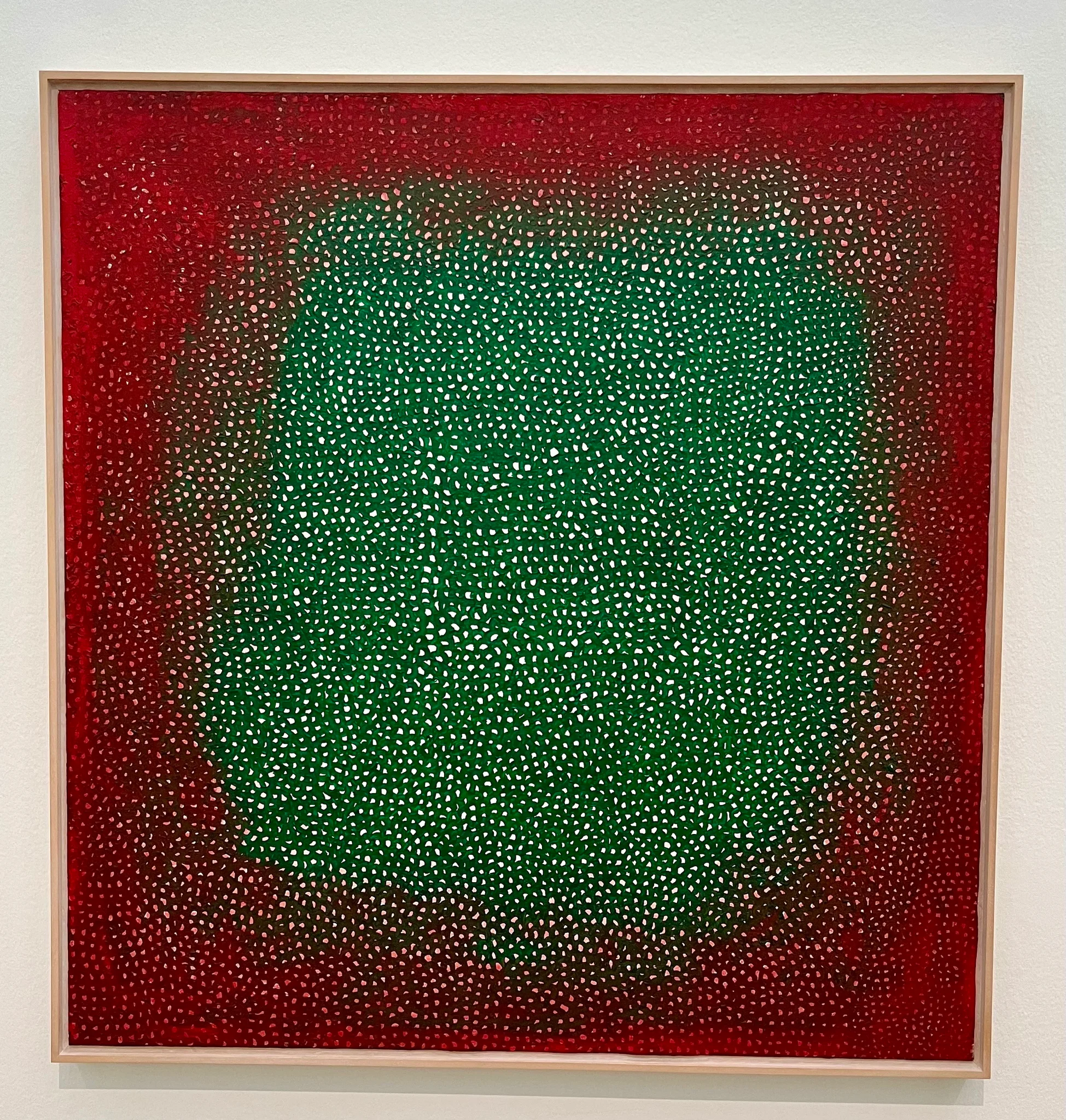 Une peinture abstraite présentant un dégradé de couleurs rouges et vertes. La composition consiste en un agencement dense de petits points blancs, créant une texture et une profondeur au sein des champs de couleurs vives. L'œuvre est encadrée et exposée sur un mur blanc.
An abstract painting featuring a gradient of red and green colors. The composition consists of a dense arrangement of small white dots, creating texture and depth within the fields of bright colors. The work is framed and displayed on a white wall. Une peinture abstraite présentant un dégradé de couleurs rouges et vertes. La composition consiste en un agencement dense de petits points blancs, créant une texture et une profondeur au sein des champs de couleurs vives. L'œuvre est encadrée et exposée sur un mur blanc.
An abstract painting featuring a gradient of red and green colors. The composition consists of a dense arrangement of small white dots, creating texture and depth within the fields of bright colors. The work is framed and displayed on a white wall.