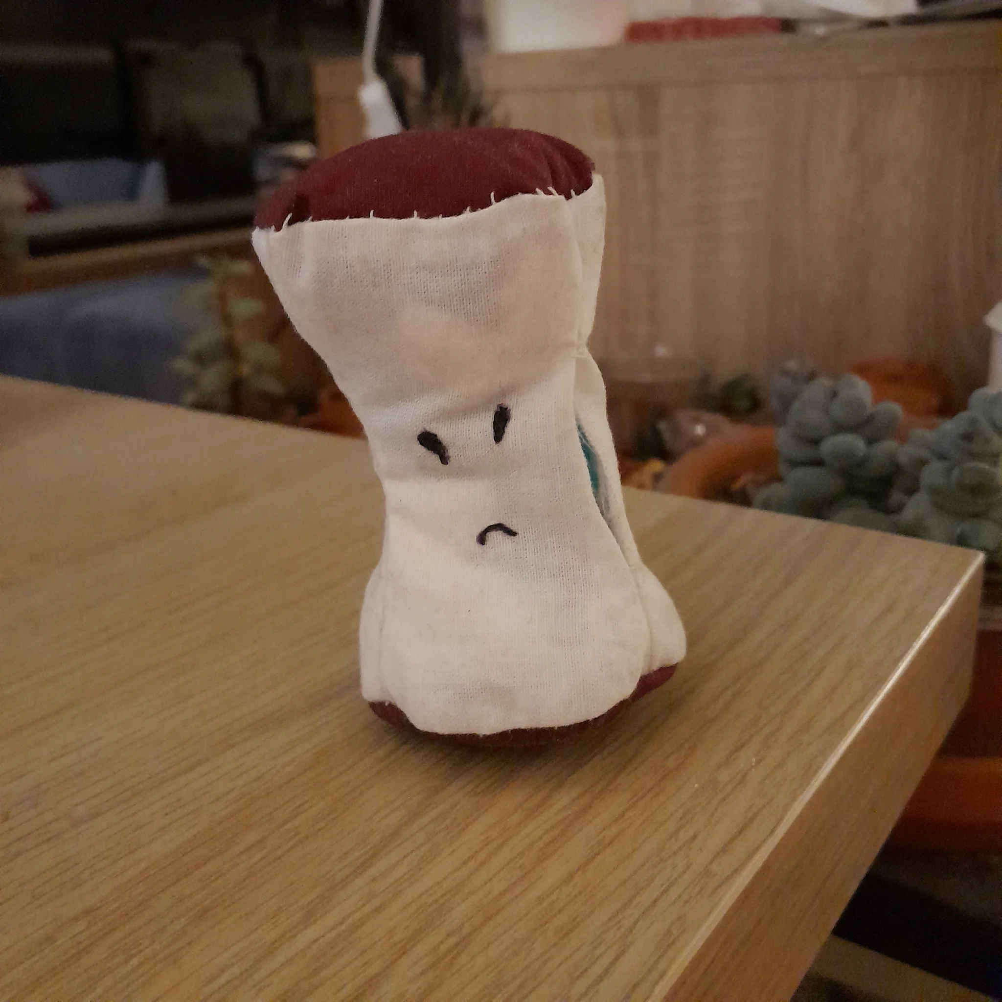 ladite petite figure de trognon de pomme avec un visage grognon dessus. ladite petite figure de trognon de pomme avec un visage grognon dessus.