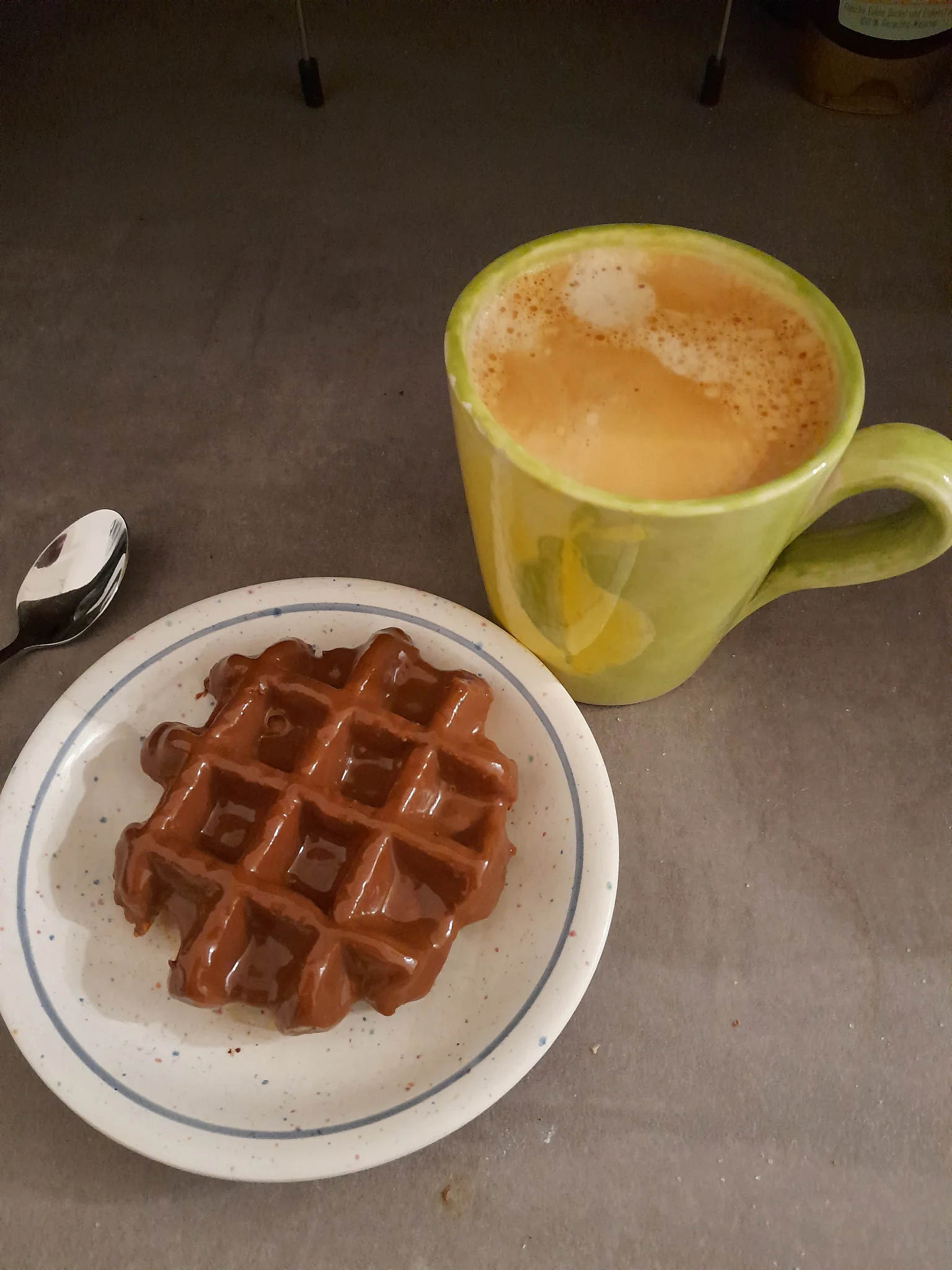 Une gauffre avec glaçage chocolat très luisant à coté d'une tasse de café. Une gauffre avec glaçage chocolat très luisant à coté d'une tasse de café.